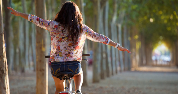 Mädchen fährt mit dem Rad durch einen Wald